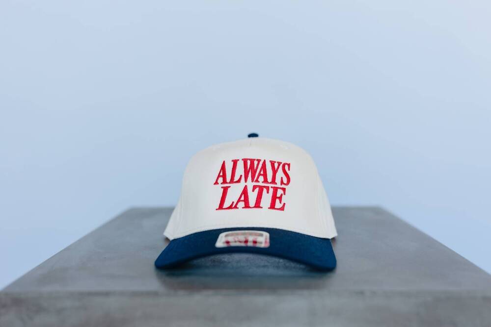 NEW THE BABE CO. men's always late embroidered trucker hat in white/navy/red